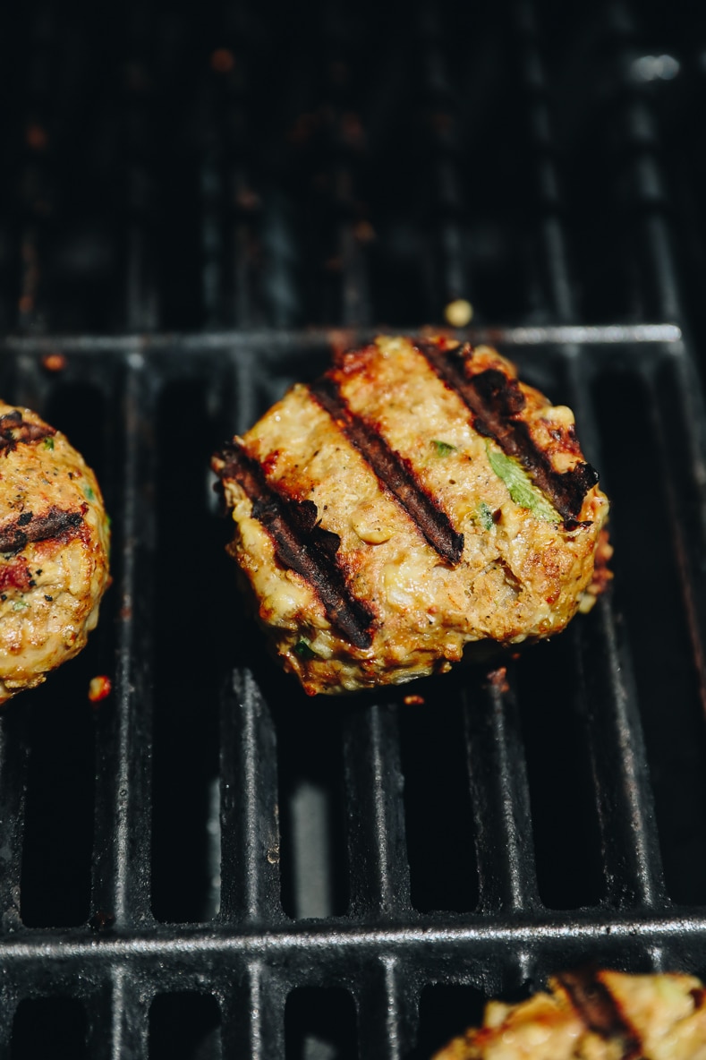 burgers cooking on a grill.