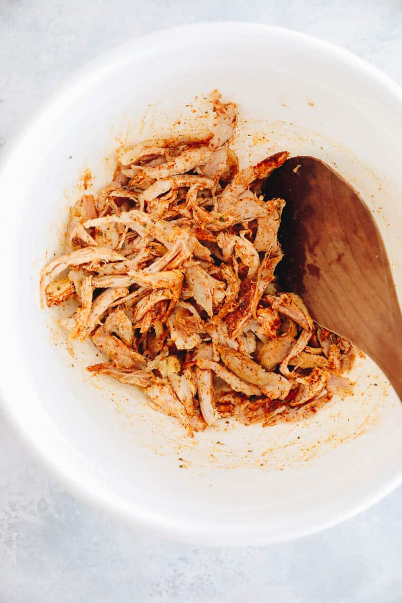 shredded chicken with taco seasoning in a white bowl