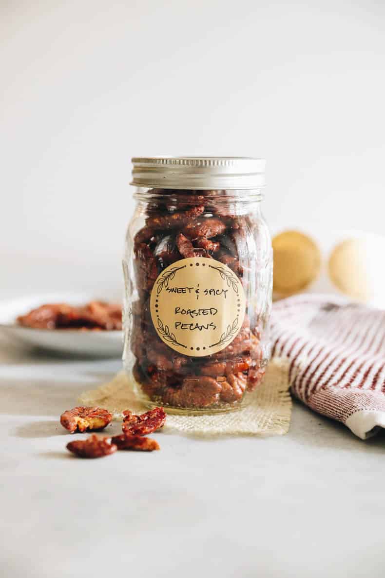 Sweet and spicy roasted pecans in a mason jar with a brown canning label.