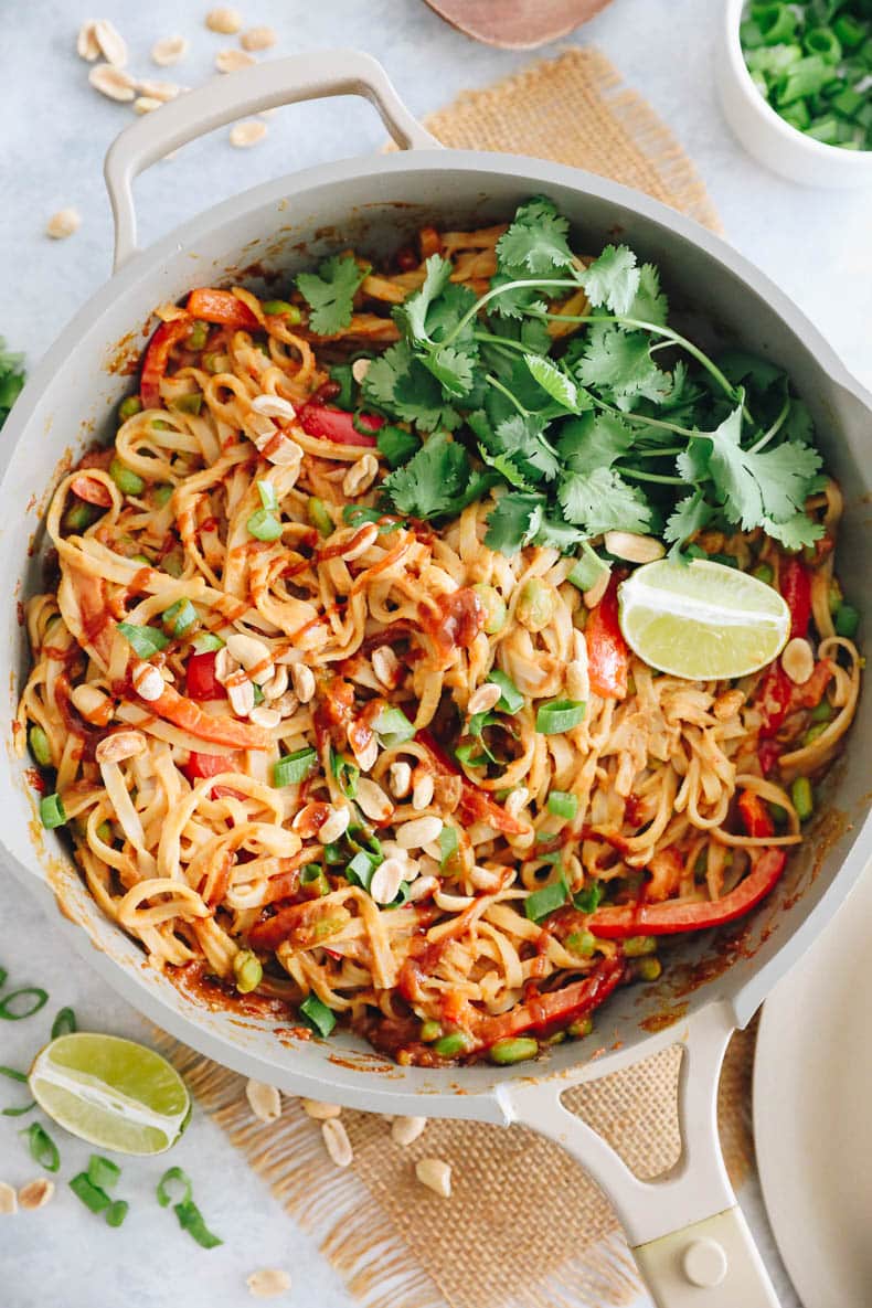overhead image of rice noodles in a spicy peanut sauce with bell pepper, and edamame